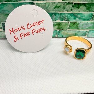 Handmade open gold tone band with emerald on one end and pearl on the.